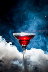 red cocktail with ice vapor, blue background