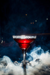 red cocktail with ice vapor, blue background