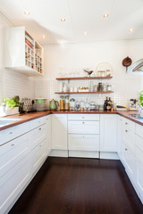 Fototapeta na wymiar kitchen interior with dark wooden floor and white cupboards