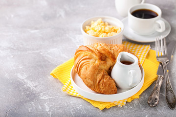 Breakfast - croissant, egg and coffee. Selective focus. Copy space
