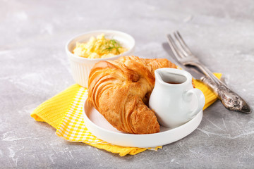Breakfast - croissant, egg and coffee. Selective focus. Copy space