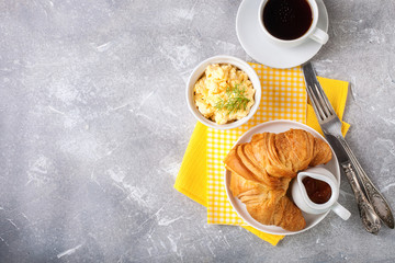 Breakfast - croissant, egg and coffee. Selective focus. Copy space. Top view