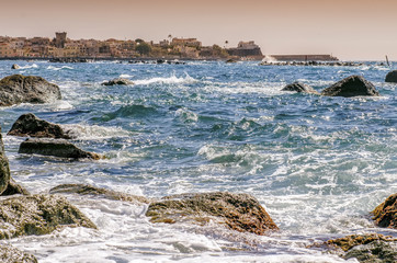 The waves crash on the cliff of Forio sunset in Ischia, Italy