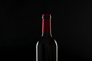 Bottle of wine on wooden table. Backlighting. Horizontall studio shot.
