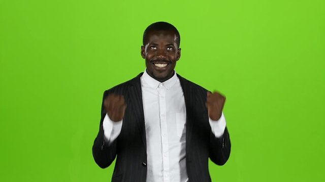 African american in the strict black suit is happy with his victory. Green Screen. Slow motion