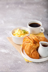 Breakfast - croissant, egg and coffee. Selective focus. Copy space