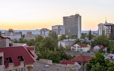 View on central district, parliament and ministry of agriculture in chisinau city, sunset with yellow sky, Moldova