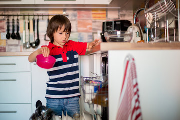 Preschool child, boy, helping mom, putting dirty dishes in dishwasher