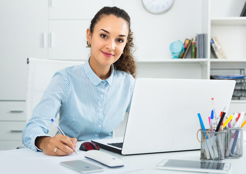 Smiling businesswoman working with documents in office
