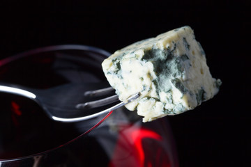 Blue cheese and glass of red wine .