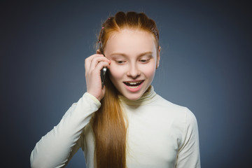 Cute little girl speaking on the cell phone. isolated on gray