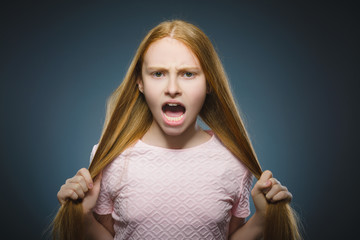 angry redhead girl isolated on gray background.