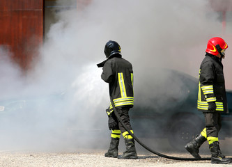 firefighters with protective uniform and helmet off the fire at