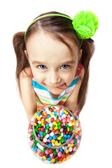 Funny child with candys licking her lips on a white background. Happy little girl with sweets.
