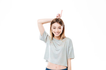 Portrait of a smiling young girl holding finger up