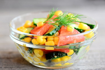 Colorful vegetable salad. Bright, vitamin and flavorful salad in a bowl isolated on wooden background. Homemade diet vegetable salad photo. Closeup