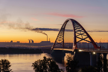 Bridge over river in the city at spectacular sunrise in the background
