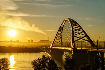 Bridge over river in the city at spectacular sunrise in the background
