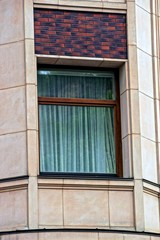 Современное окно со шторой на здании жилого дома