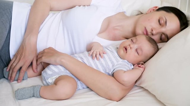mom and son newborn sleeping in bed
