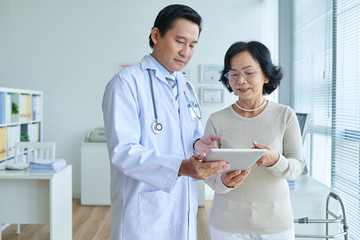 Asian Cardiologist Analyzing Electrocardiogram