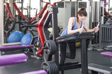 Young woman working her quads at machine press in the gym