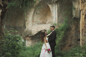 Just married poses and kissing with an old fortress on the background