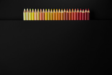 Colour pencils isolated on black background close up