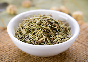 Dried rosemary leaves in a bowl