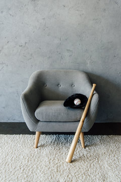 Baseball Bat And Ball With Glove On Textile Armchair At Empty Room