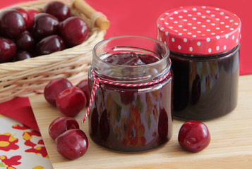 Sweet cherry jam and fresh cherries on background. 