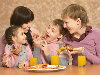 Obraz na płótnie Canvas Mother with children eating pizza