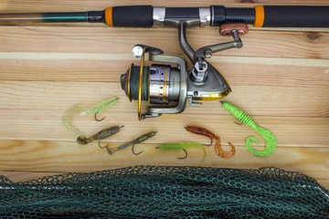 Silicone spoon-baits with a sachet and a spinning coil оn a wooden table