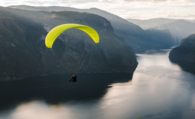 Paraglider silhouet vliegen over Aurlandfjord, Noorwegen