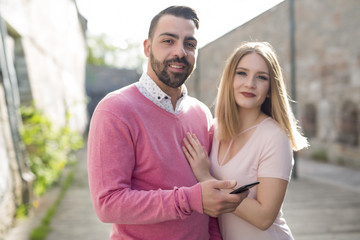 Fototapeta premium Attractive young couple in casual style on a date with cellphone