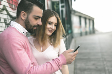 Attractive young couple in casual style on a date with cellphone
