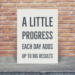 Inspiration Quote on paper at marble stone table top and brick wall background