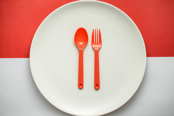White plate  on Indonesian flag with plastic red fork and spoon.