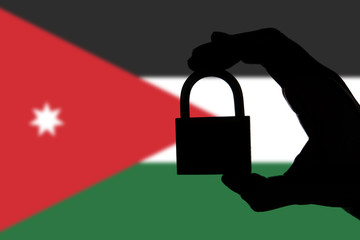 Jordan security. Silhouette of hand holding a padlock over national flag