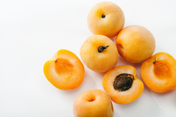 Fresh apricots whole and sliced on white background. Copy space