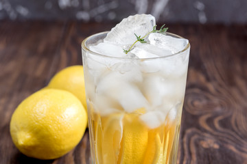 Glass of ice tea with lemon on wooden table Vertical photo Close up 
