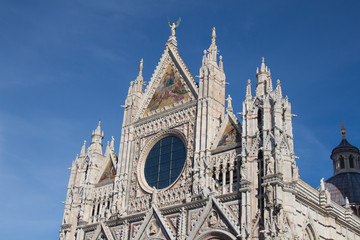 Fototapeta premium Upper facade detail of Duomo di Siena or Metropolitan Cathedral of Santa Maria Assunta. Tuscany. Italy.