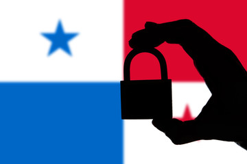 Panama security. Silhouette of hand holding a padlock over national flag