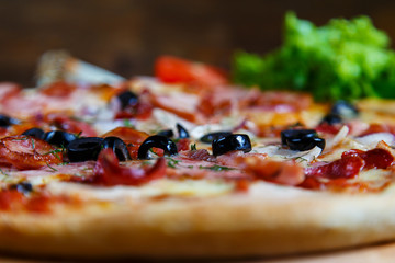 Delicious homemade pizza with mozzarella, ham, olives and fennel.