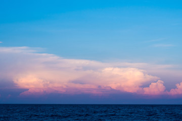 Fototapeta na wymiar Pink clouds and sunset sky over sea