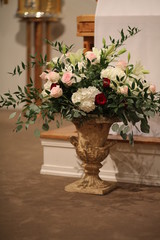 Fototapeta na wymiar Wedding Decor Flowers: Urn of Pink, White, and Red Roses and Hydrangeas in a Catholic Church