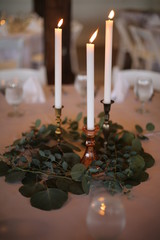 Wedding Reception Decor: Brass Candle Holders with Tapered Candles Dripping onto Eucalyptus Greenery
