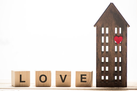 Wooden block cubes with love sign and wooden house model isolated on white