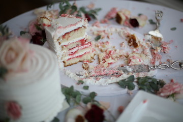 Messy Wedding Cake that Has Already Been Sliced with Roses
