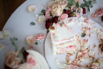 Messy Wedding Cake that Has Already Been Sliced with Roses